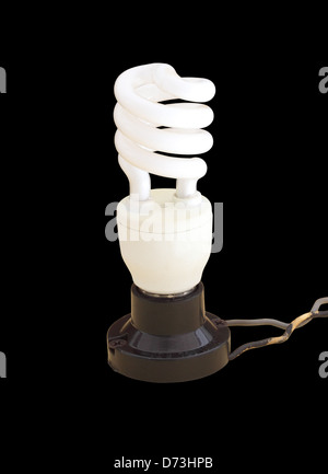 energy saving fluorescent light bulb with wire on black background Stock Photo