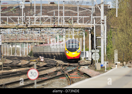 Virgin pendolino express passenger train tilting on the approach to Stafford station Stock Photo