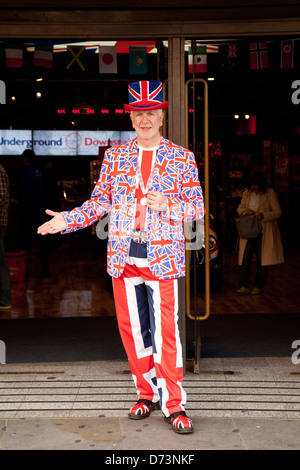 A man stands dressed in a union jack suit outside a souvenir shop in ...
