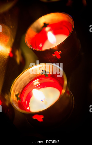 Devotional candles lighting a darkened Roman Catholic Basilica of the National Shrine of Mary, Queen of the Universe. Stock Photo