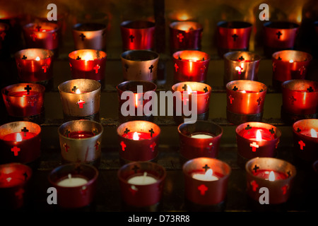 Devotional candles lighting a darkened Basilica of the National Shrine of Mary, Queen of the Universe. Stock Photo