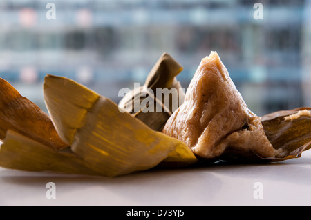 Zongzi (粽子) is a bamboo or reed leaves wrapped sticky rice dumpling eaten during the Chinese Dragon Boat Festival. Stock Photo