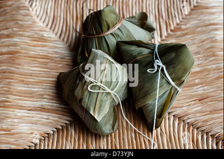 Zongzi (粽子) is a bamboo or reed leaves wrapped sticky rice dumpling eaten during the Chinese Dragon Boat Festival. Stock Photo