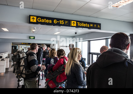 Manchester Airport - Easyjet departure gate, customers with carry on baggage. Travelling to Morocco. Stock Photo