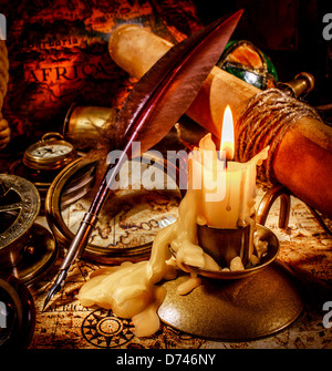 Vintage compass, magnifying glass, pocket watch, quill pen, spyglass lie on an old ancient map with a lit candle Stock Photo