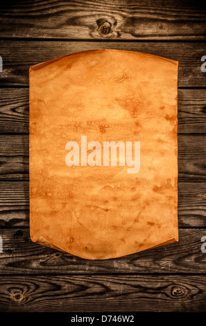 Blank old paper with curled edge against the background of an aged wood Stock Photo