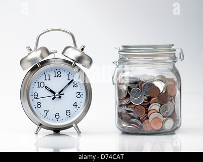 Time is Money, clock and jar full of money Stock Photo