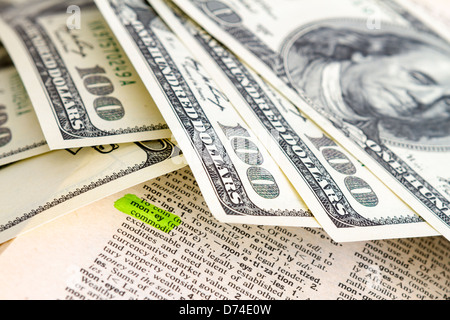 The word money in dictionary with dollars Stock Photo