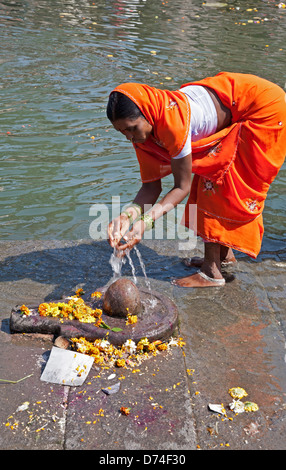 Hindu woman offering water to a Shiva linga. Godavari river. Nasik. India Stock Photo