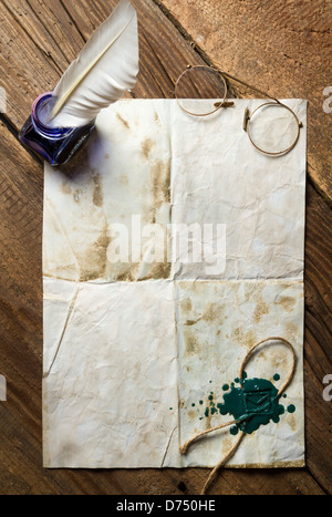 Blue ink, feather on old vintage letter with green sealing wax Stock Photo