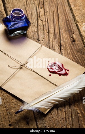 Old feather, envelope, sealing wax and ink bottle Stock Photo