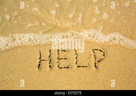 HELP - written in sand on beach texture - soft wave of the sea. Stock Photo