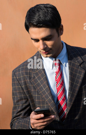Businessman text messaging on a cell phone Stock Photo