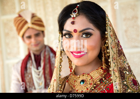 Portrait of an Indian bride smiling with groom in background Stock Photo