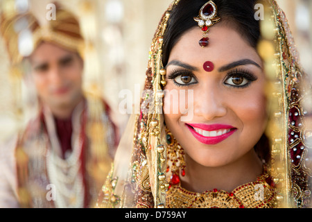 Portrait of an Indian bride smiling with groom in background Stock Photo