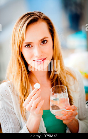 Woman taking an effervescent aspirin tablet. Stock Photo