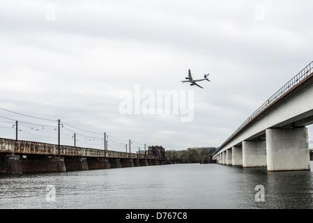 Two of the five bridges that make up what is commonly known as the 14th Street Bridge spanning the Potomac and connecting Washington DC with Virginia. at right is the Charles R. Fenwick Bridge which carries Washington Metro commuter trains. At left is the Long Bridge, which carries rail traffic. At center is a plane coming in to land at Reagan National Airport in Alexandria, VA. Stock Photo