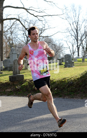 Runner races down incline competing in Half Marathon. Stock Photo