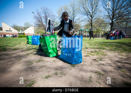 First and second graders from neighborhood schools celebrate Arbor Day playing recycling relay games Stock Photo
