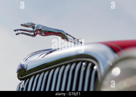 Floral Park, New York, U.S. April 28, 2013. A leaping dog hood ornament, seen in closeup, is on a red 1934 Ford 2-door sedan at the Antique Auto Show, where New York Antique Auto Club members exhibited their cars on the farmhouse grounds of Queens County Farm Museum. Its owner, Dennis Kusold of Franklin Square, explained the car has its original steel body and frame. Credit: Ann E Parry/Alamy Live News Stock Photo