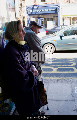 An old couple waiting at a bus stop. Stock Photo