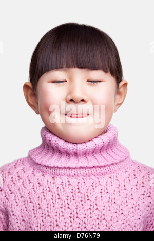 Portrait of smiling little girl sticking tongue out, studio shot Stock Photo