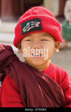 Tiny boy in Monk's robes and red hat with a his collection bowl 7 Stock Photo