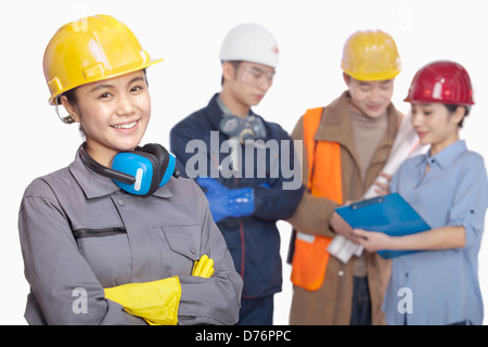 Four construction workers against white background, focus in foreground Stock Photo