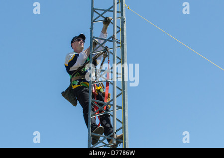 Man climbing antenna tower during amateur radio tower installation. Stock Photo