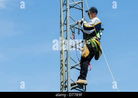 Man climbing antenna tower during amateur radio tower installation. Stock Photo