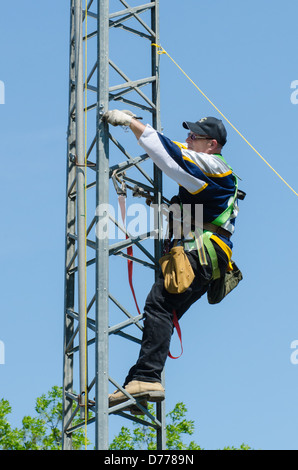 Man climbing antenna tower during amateur radio tower installation. Stock Photo