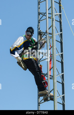 Man climbing antenna tower during amateur radio tower installation. Stock Photo