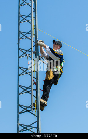 Man climbing antenna tower during amateur radio tower installation. Stock Photo