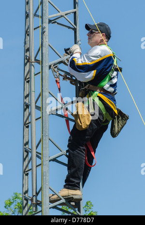 Man climbing antenna tower during amateur radio tower installation. Stock Photo