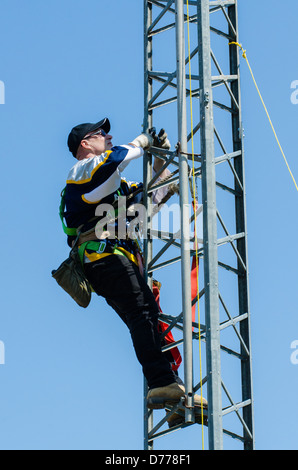 Man climbing antenna tower during amateur radio tower installation. Stock Photo