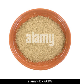 Top view of a small portion of organic active dry yeast in a red clay dish on a white background. Stock Photo