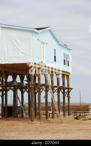 House elevated on pilings protection hurricane storm surge on Gulf Mexico Peveto Beach Louisiana USA Stock Photo