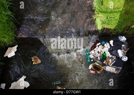 Plastic waste floating in a small river, pollution Stock Photo