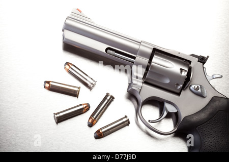 gun with bullets on steel surface - modern revolver handgun Stock Photo