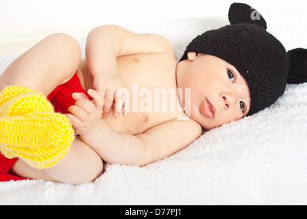 Beautiful baby boy laying in colorful crochet costume Stock Photo