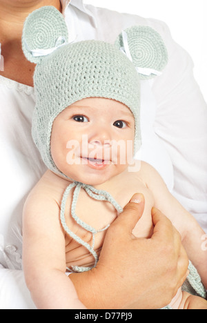 Happy newborn baby boy with crochet mouse cap in mother hands Stock Photo