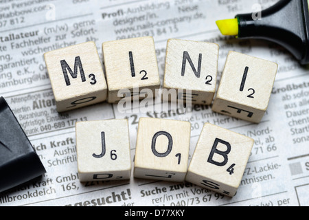 Stroke minijob from cube letter on newspaper advertisements Stock Photo