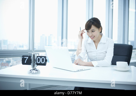 businesswoman sitting at desk Stock Photo