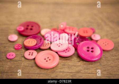 A handful of pink buttons on a wooden background Stock Photo