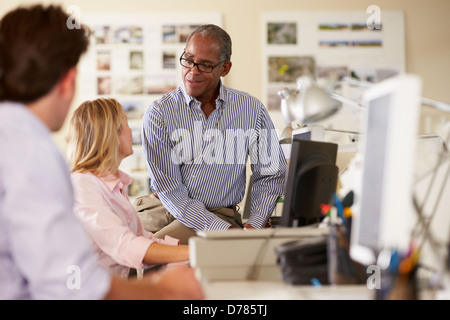 Workers At Desks In Busy Creative Office Stock Photo