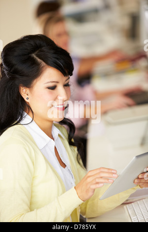 Woman Using Digital Tablet In Busy Creative Office Stock Photo