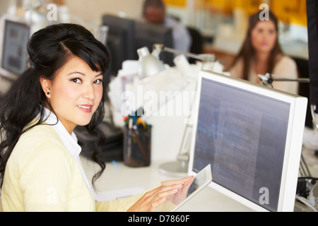 Woman Using Digital Tablet In Busy Creative Office Stock Photo