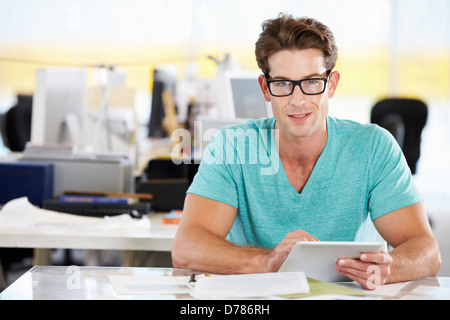 Man Using Digital Tablet In Busy Creative Office Stock Photo