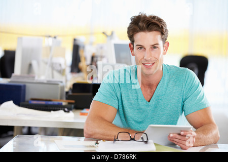Man Using Digital Tablet In Busy Creative Office Stock Photo