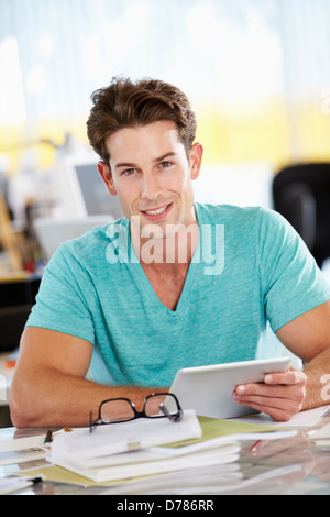 Man Using Digital Tablet In Busy Creative Office Stock Photo